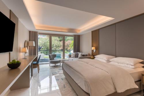 a bedroom with a large bed and a living room at Hyatt Regency Kotor Bay Resort in Kotor