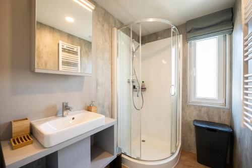 La salle de bains est pourvue d'un lavabo et d'une douche. dans l'établissement Vakantiepark duinzicht, à Koudekerke