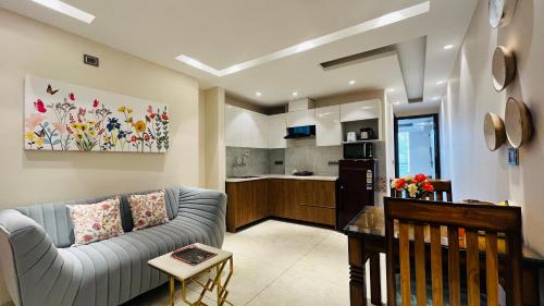 a living room with a couch and a kitchen at BluO 1BHK Suite - Balcony, Lift, Gym, Parking in Gurgaon