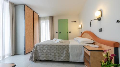 a bedroom with a bed and a green door at Hotel Nobel in Rimini
