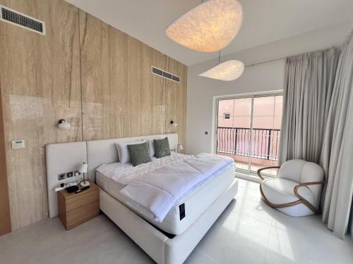 a bedroom with a large bed and a chair at Nad Al Sheba 3 - 5BR Villa - Allsopp&Allsopp in Dubai