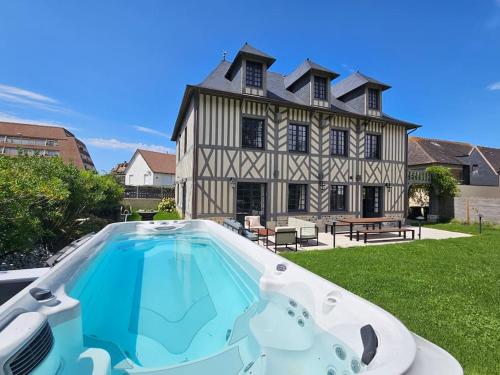 a house with a swimming pool in front of it at Villa d'exception, 5 chambres, 20m plage, spa. in Bénerville-sur-Mer