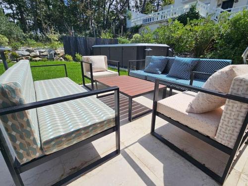 a group of chairs and tables on a patio at Villa d'exception, 5 chambres, 20m plage, spa. in Bénerville-sur-Mer