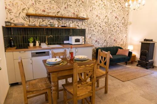 cocina y sala de estar con mesa y sillas en EgerCottages - Rosé Cottage en Eger