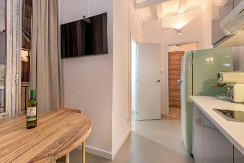 a bottle of wine sitting on a wooden table in a kitchen at La Guarida Suites in Barcelona