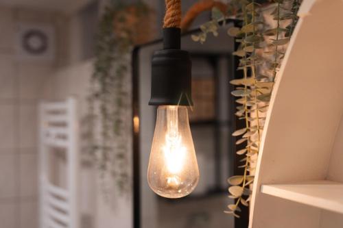 a light bulb hanging from a wall next to a refrigerator at Adventure Apartment - Hochebene, Terrasse & Top Lage in Bremerhaven