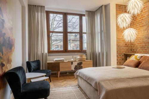 a bedroom with a bed and a desk and a window at Apartamenty Krupówki Brama 27 in Zakopane