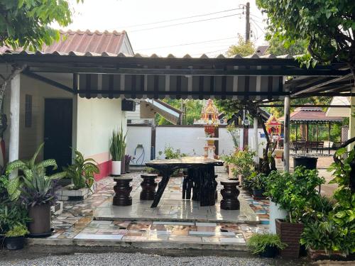 un patio con una mesa de picnic bajo una pérgola en Suanpai Resort Sattahip en Ban Tao Than