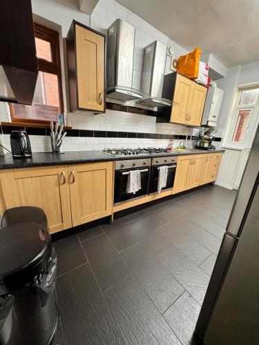 a kitchen with wooden cabinets and a stove top oven at Langleys Private Double Room Selly Oak in Birmingham