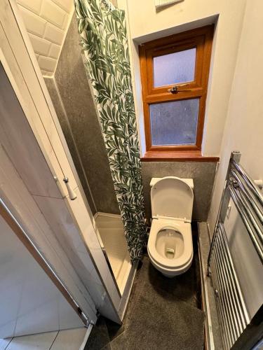 a small bathroom with a toilet and a window at Langleys Private Double Room Selly Oak in Birmingham