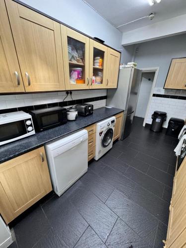 Il comprend une cuisine équipée d'une cuisinière et d'un réfrigérateur. dans l'établissement Langleys Private Double Room Selly Oak, à Birmingham