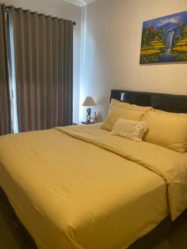a large yellow bed in a bedroom with a window at Queens Villa in Seminyak