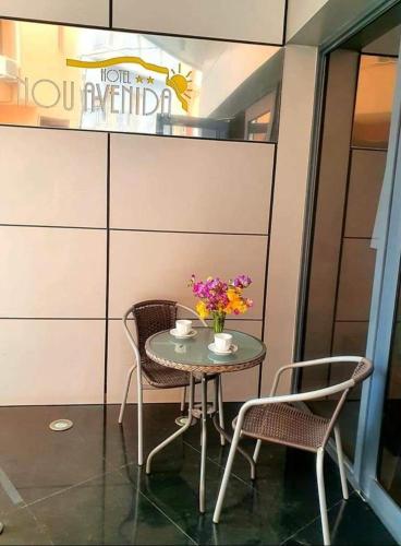 a table with two chairs and a table with flowers on it at Nou Avenida in Gata de Gorgos