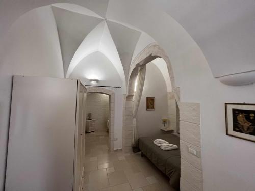 a hallway with an archway and a bed in a room at La Rosa D Ernesto WiFi free 3 sleeping places in Ostuni