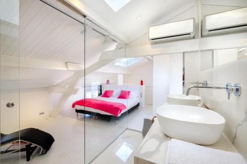 a bathroom with a sink and a bed in a room at Appartement de luxe bluesky in Beausoleil