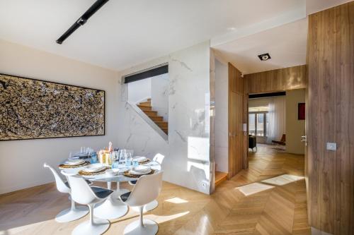 a dining room with a table and white chairs at Appartement de luxe - Bluesky in Beausoleil