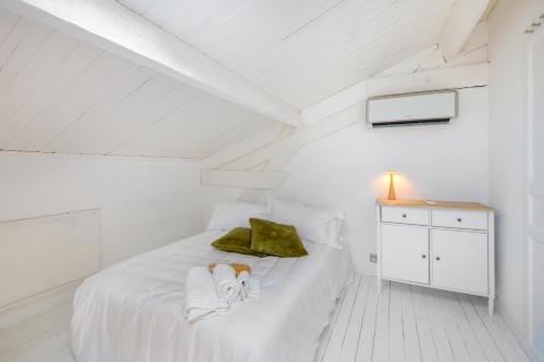 a white bedroom with a bed with a dog on it at Appartement de luxe - Bluesky in Beausoleil