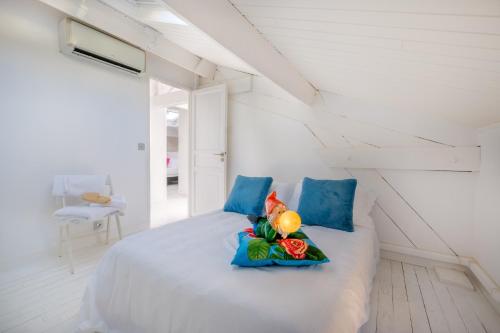 ein Schlafzimmer mit einem Bett mit blauen Kissen und Blumen darauf in der Unterkunft Appartement de luxe bluesky in Beausoleil