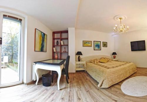 a bedroom with a bed and a desk and a window at Cosy Studio with Garden Near the Prague Airport 
