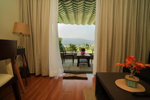 a living room with a large window and a table with a view at Gaurav Lords Resort in Srīvardhan