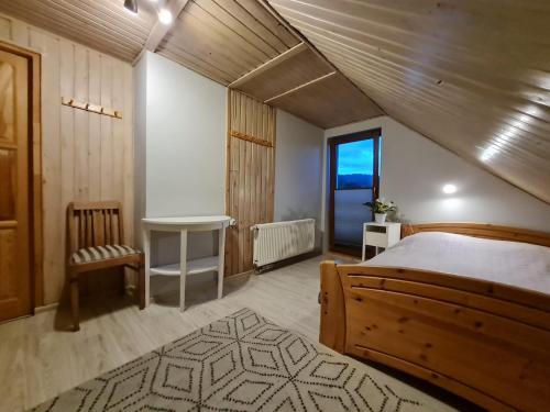 1 dormitorio con cama, mesa y ventana en Koliba nad Białką, en Czarna Góra