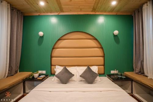 a bedroom with a bed with a green wall at Zostel Mussoorie (Mall Road) in Mussoorie