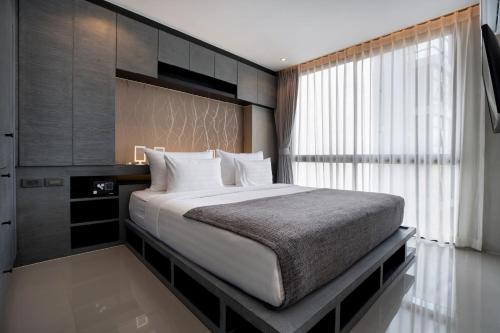 - une chambre avec un grand lit et une fenêtre dans l'établissement Citygate Condo L704, near FantaSea & Café Del Mar Kamala Beach Club, à Kamala Beach