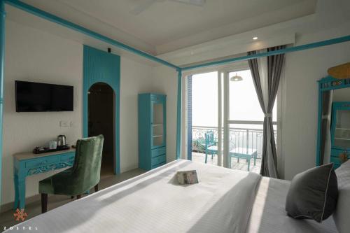 a bedroom with a bed and a desk and a window at Zostel Mussoorie (Mall Road) in Mussoorie