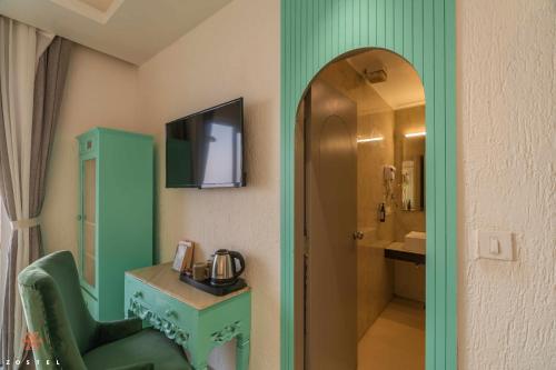 a bathroom with a green room with a sink and a mirror at Zostel Mussoorie (Mall Road) in Mussoorie