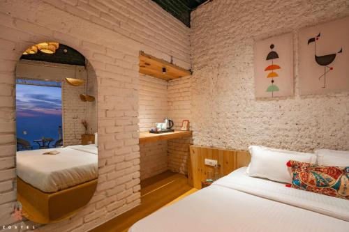 a bedroom with two beds in a brick wall at Zostel Mussoorie (Mall Road) in Mussoorie