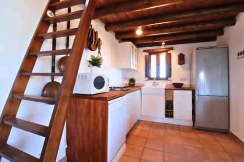 a kitchen with white cabinets and a spiral staircase at Finca Santa Ana - Only Adults in Cortelazor