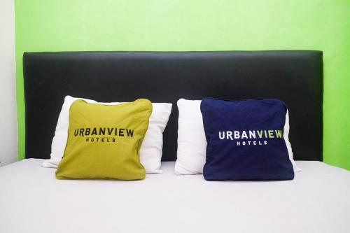 two pillows sitting on top of a bed at Urbanview Hotel AVA Semarang near Akademi Kepolisian Semarang by RedDoorz in Jatingaleh