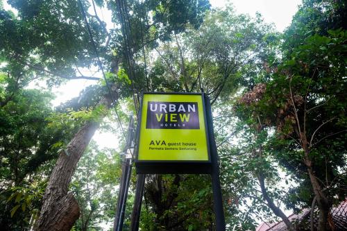 a sign that says urban view in front of trees at Urbanview Hotel AVA Semarang near Akademi Kepolisian Semarang by RedDoorz in Jatingaleh