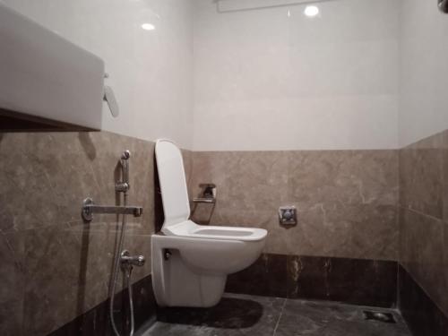 uma casa de banho com um WC e um chuveiro em Hotel Raheja Residency em Mumbai