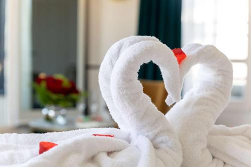a towel shaped like a swan sitting on a bed at Best Western Hotel du Pont Wilson in Lyon