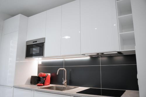 a kitchen with a sink and a microwave at Appartement Paris La Défense U Arena in Nanterre