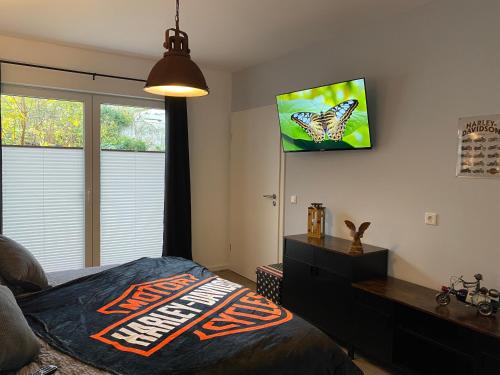 1 dormitorio con 1 cama y TV en la pared en Route 66 Appartement, en Bad Salzuflen