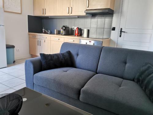 een woonkamer met een blauwe bank in een keuken bij Charmant appartement à 1 minute du lac in Annecy