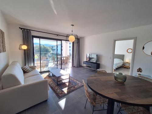 un salon avec un canapé et une table dans l'établissement Domaine d'Arca - Flaubert 12 - 4 pers - étage 1, à Porto-Vecchio