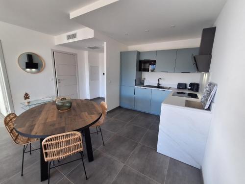 une cuisine et une salle à manger avec une table et des chaises en bois dans l'établissement Domaine d'Arca - Flaubert 12 - 4 pers - étage 1, à Porto-Vecchio