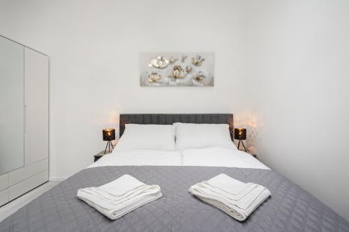 ein Schlafzimmer mit einem Bett mit zwei Handtüchern darauf in der Unterkunft Stellar Dwell Apartment in Budapest