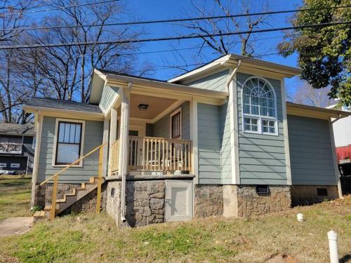 a small blue house with a porch and a balcony at Cozy Center City Cottage*Walk to center city in Charlotte