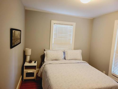 a small bedroom with a bed and a night stand at Cozy Center City Cottage*Walk to center city in Charlotte