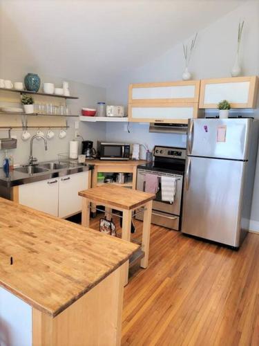 a kitchen with stainless steel appliances and wooden floors at Cozy Center City Cottage*Walk to center city in Charlotte
