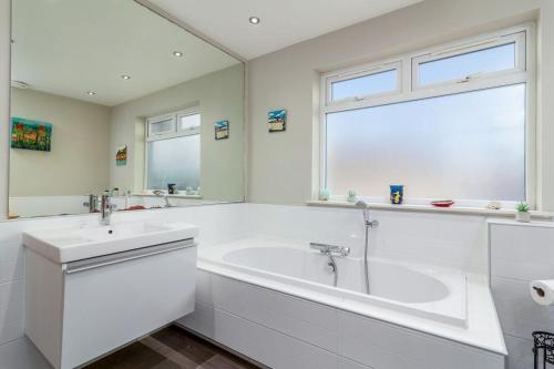 Baño blanco con bañera y lavamanos en Kilrymont View en St Andrews