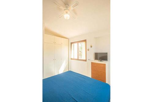 Un dormitorio con una cama azul y un ventilador de techo. en Giglio Viola, en Campese