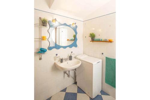 Un baño con lavabo, inodoro y espejo. en Giglio Viola, en Campese