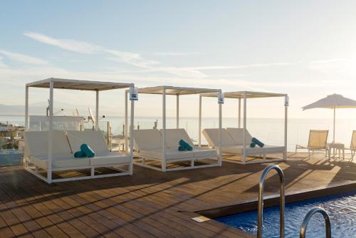 een terras met ligstoelen en een zwembad bij Aluasun Lago Rojo - Adults recommended in Torremolinos