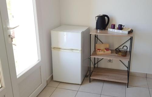 a kitchen with a white refrigerator and a shelf at Bamboo in Mison
