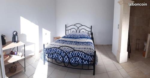 a bedroom with a bed with a blue and white comforter at Bamboo in Mison